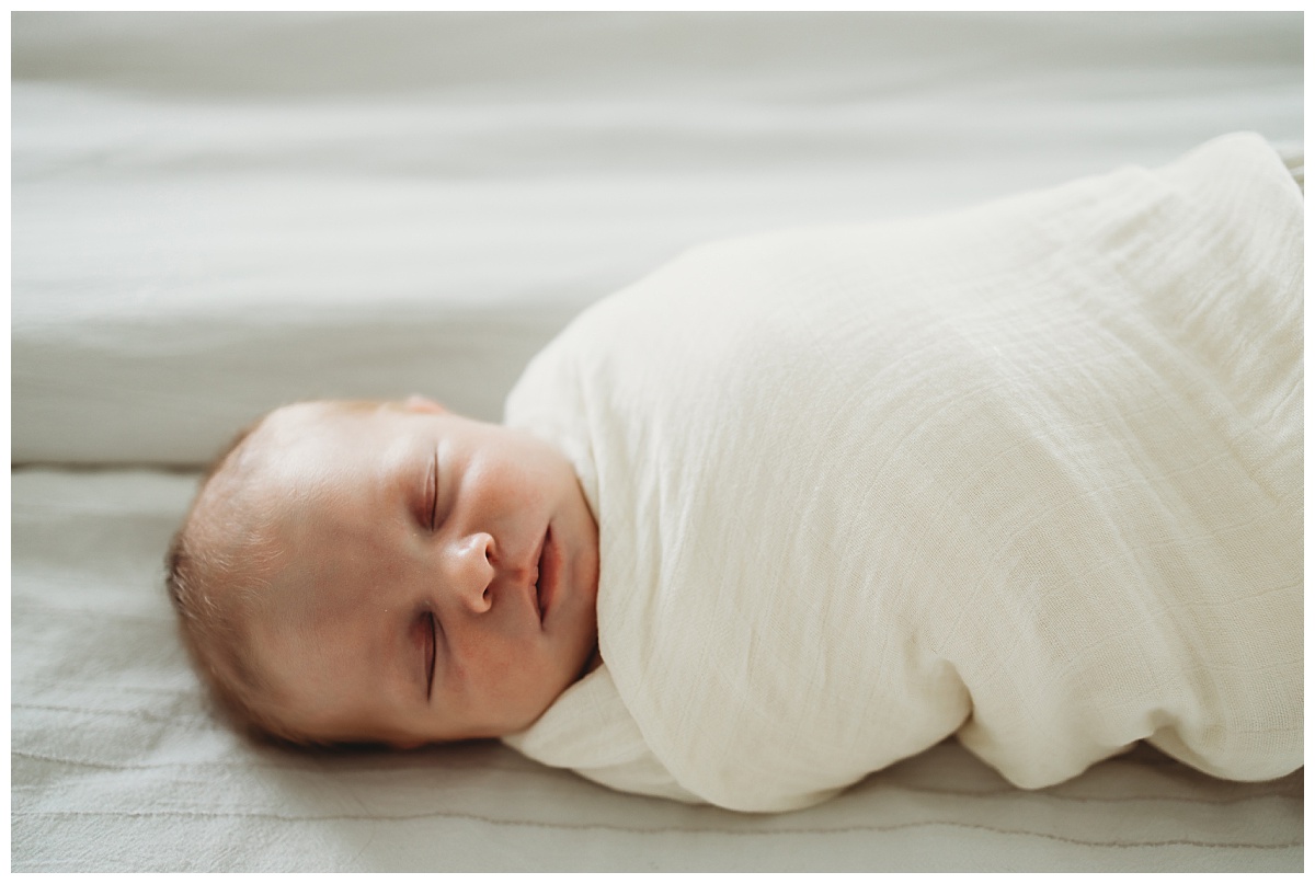 baby swaddled in cream-colored blanket by Denver newborn photographer