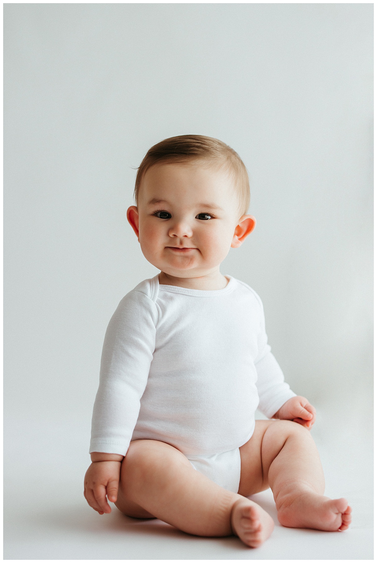 infant proudly sits while smiling for Your Modern Story