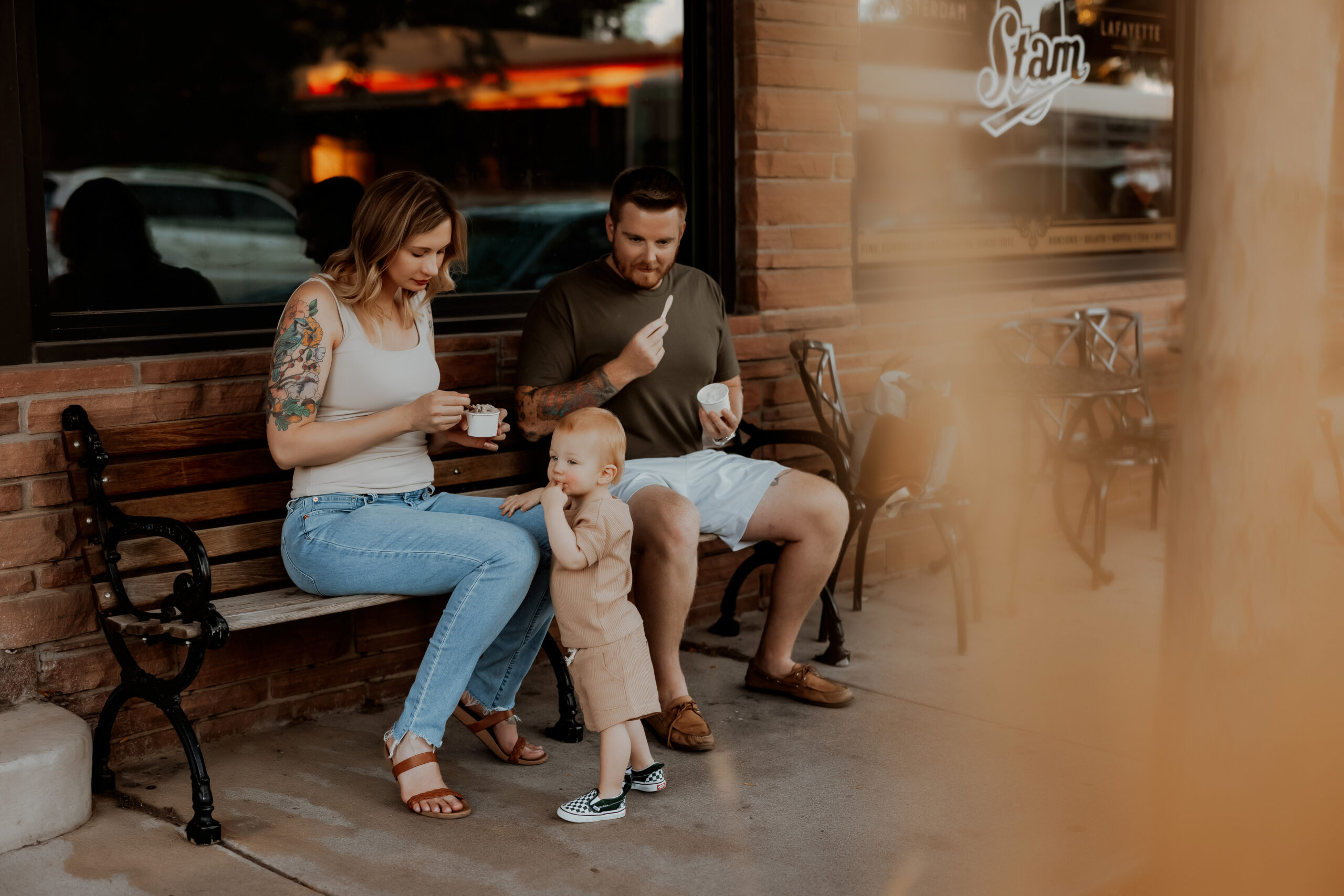Family of three eating ice cream outside for lifestyle family session in Thornton Colorado